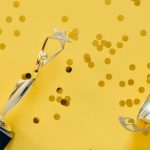 Golden trophy with celebratory confetti on a vibrant yellow background.
